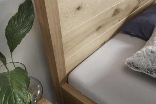 Modernes Holzbett mit Pflanzen auf Holzschrank