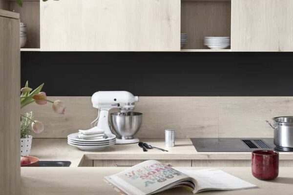 Moderne Küche mit Holzschränken und Küchenmaschine, offenes Kochbuch