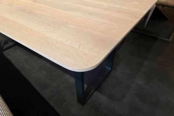 Moderner Holztisch mit Metallbeinen auf dunklem Boden
