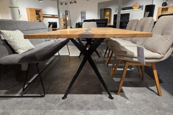 Moderner Esszimmertisch mit Metallbeinen und gepolsterten Stühlen in einem Möbelgeschäft