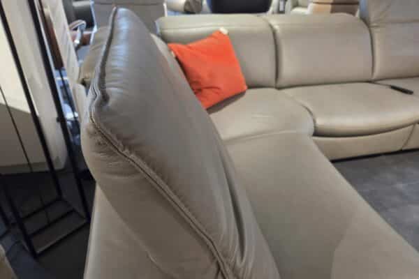 Graues Ledersofa mit rotem Kissen in modernem Wohnzimmer