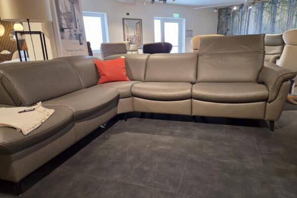 Graues Ledersofa mit orangefarbenem Kissen im Wohnzimmer