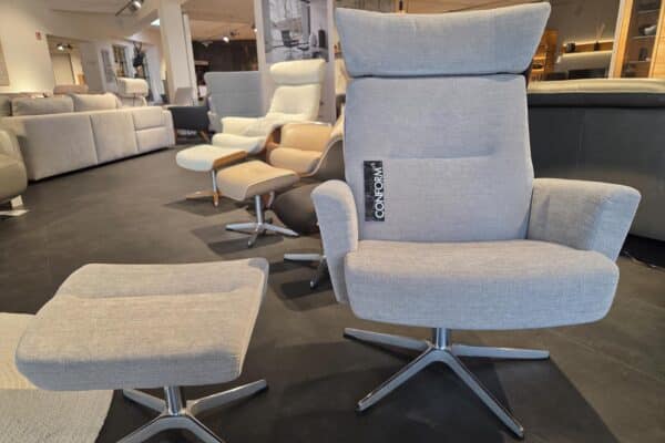 Grauer Sessel mit Hocker in einem Möbelgeschäft