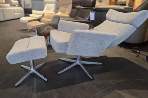 Grauer Relaxsessel mit Hocker im Möbelgeschäft