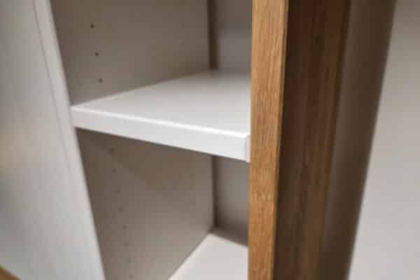 Nahaufnahme eines Holzregals mit weißen Einlegeböden