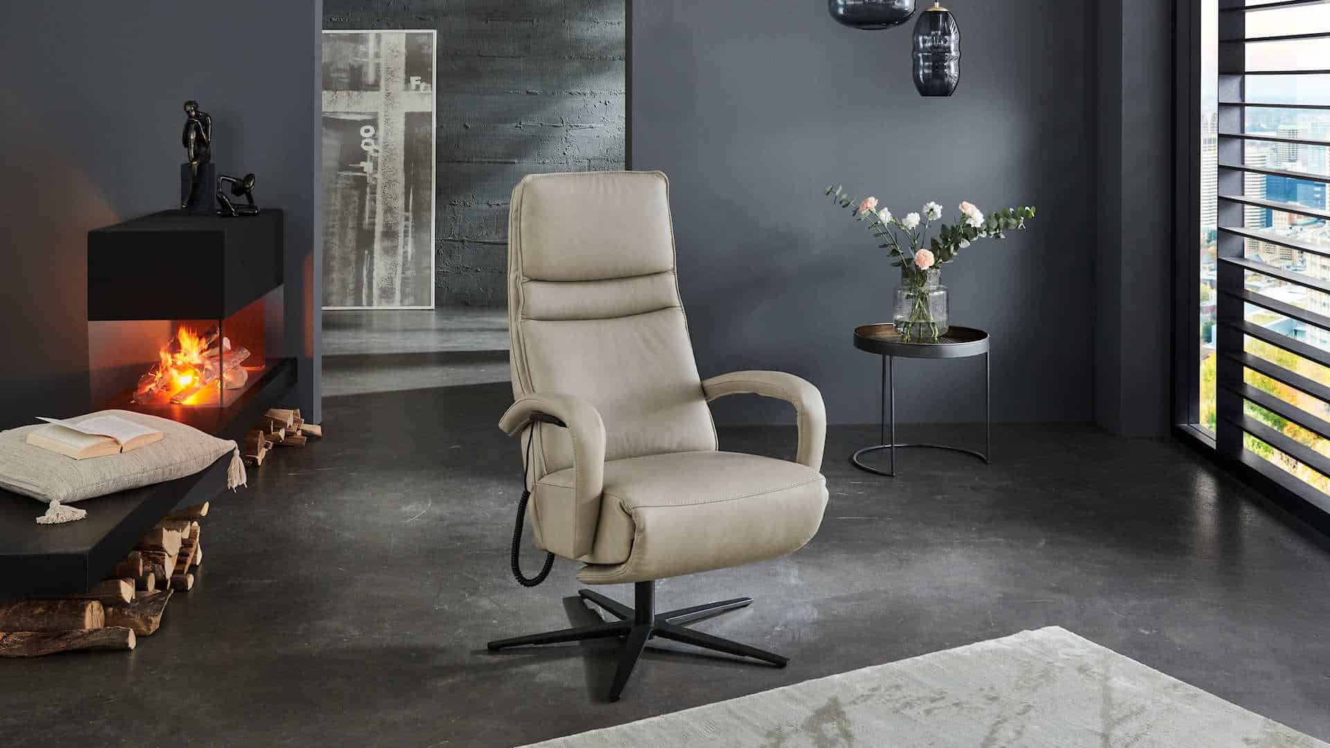 Moderner hellgrauer Sessel vor Kamin in stilvollem Wohnzimmer